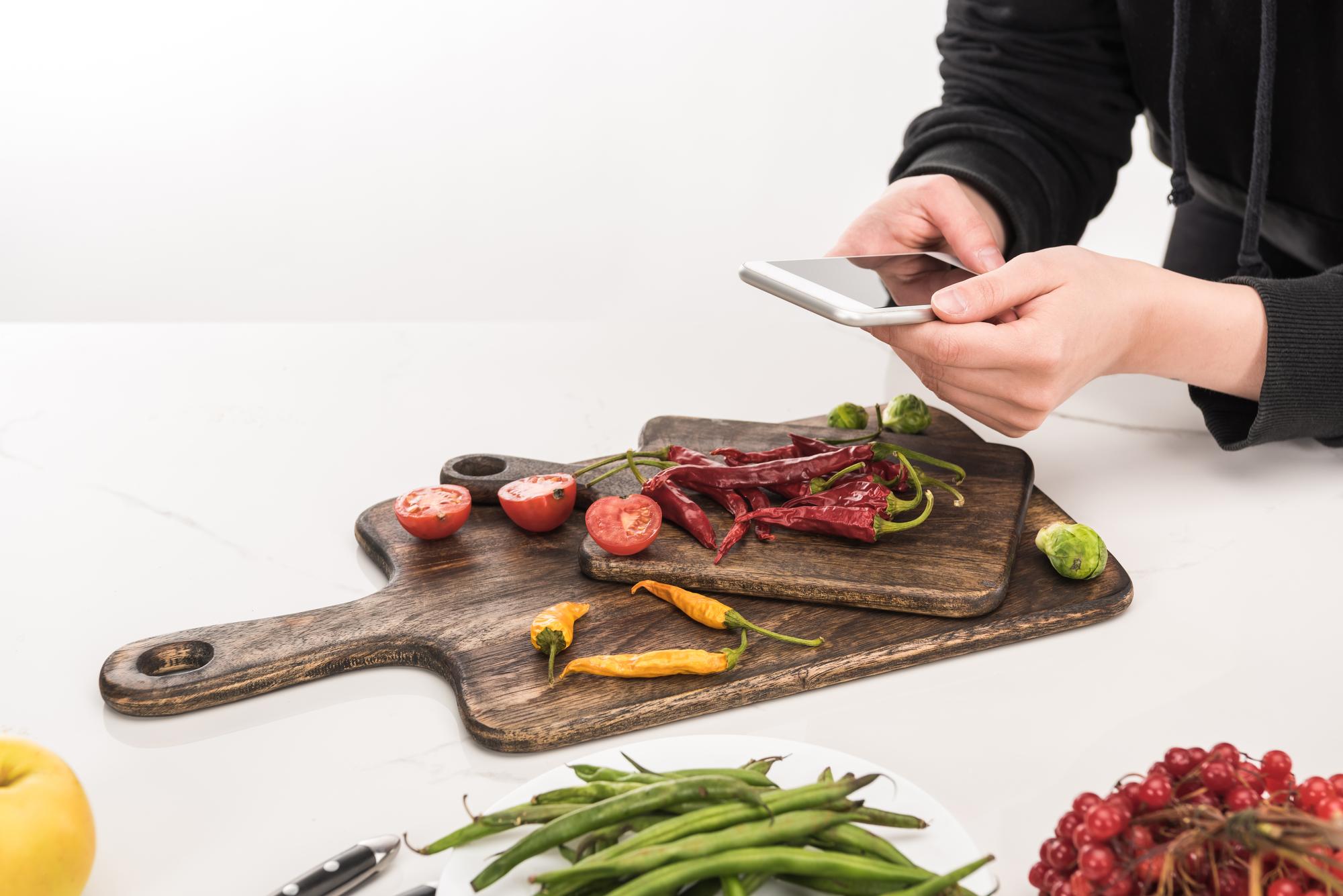 Student slicing roasted vegetables on a cutting board